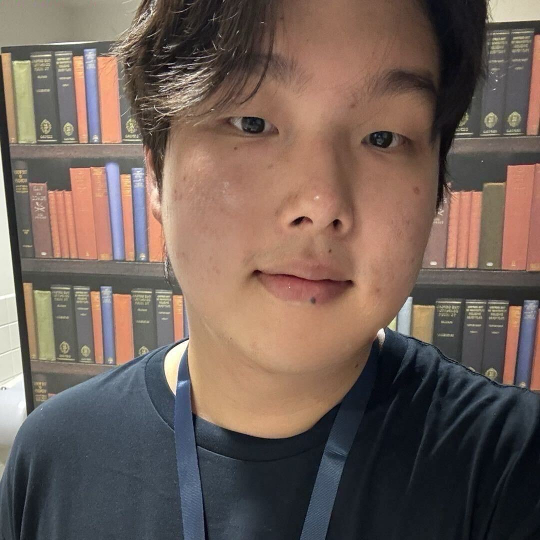 Kaichen Guo in front of a bookshelf.